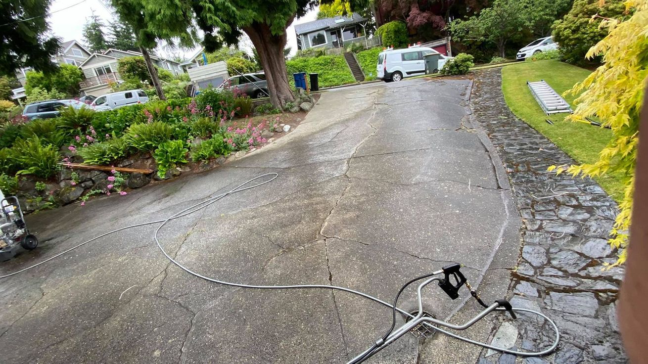 A residential driveway in Seattle still wet after pressure washing service