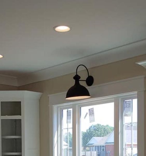 Kitchen ceiling with a black pendant light above a window and white cabinets
