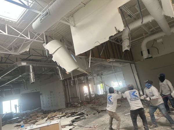 A group of construction workers are working on the ceiling of a building.