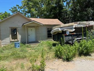 A small house with a trailer parked in front of it.