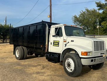 A dump truck is parked on the side of the road.