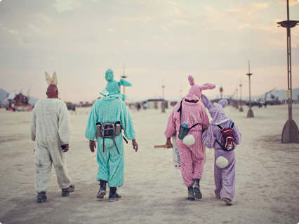 a group of people in bunny costumes are walking in the desert .