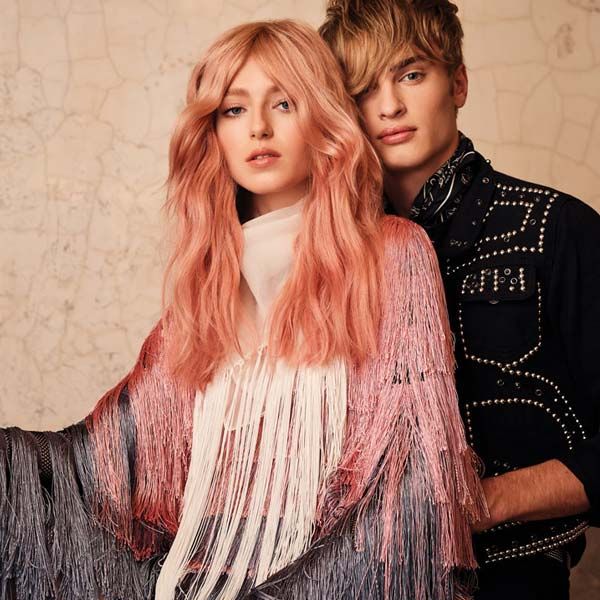 A woman with pink hair is standing next to a man