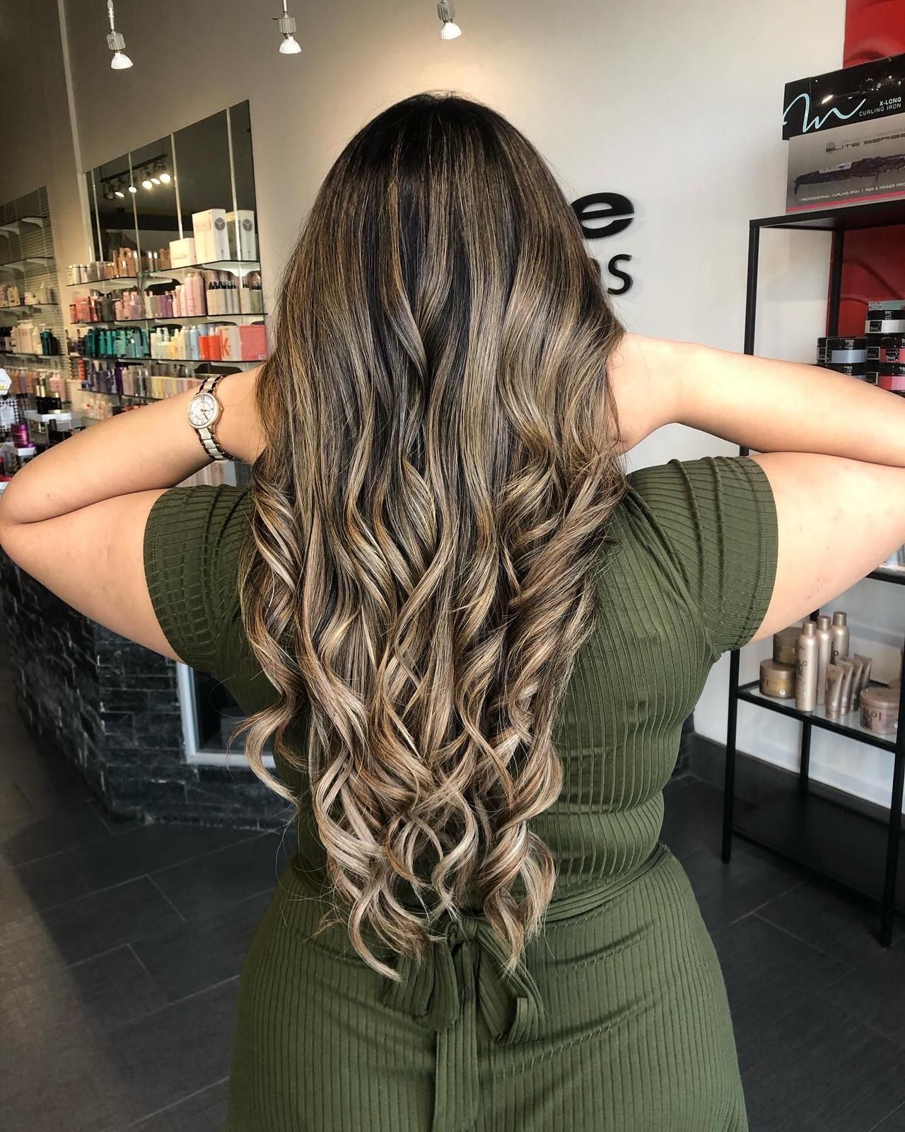 The woman is wearing a green dress and has long wavy hair.