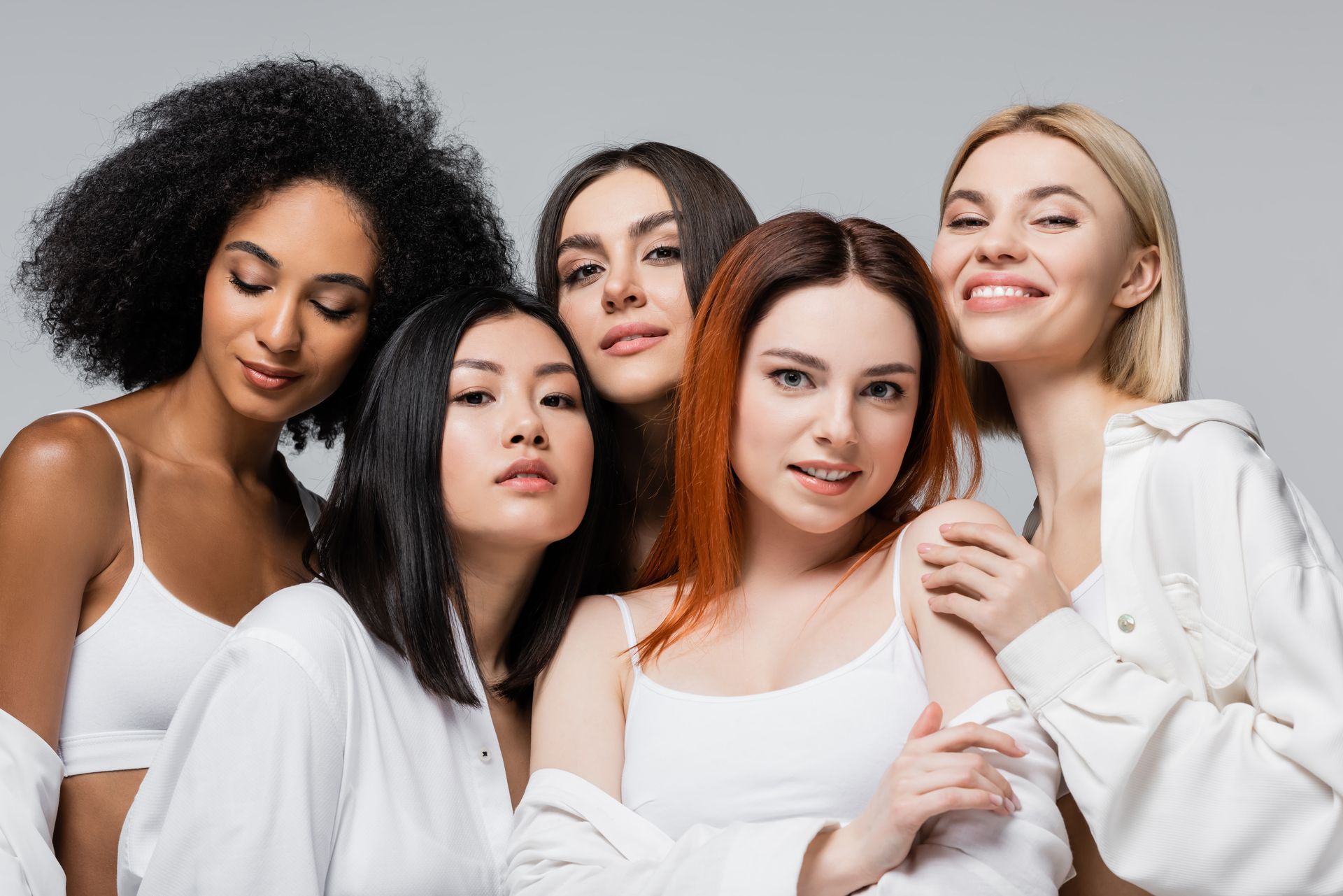 A group of women of different races are posing for a picture together.