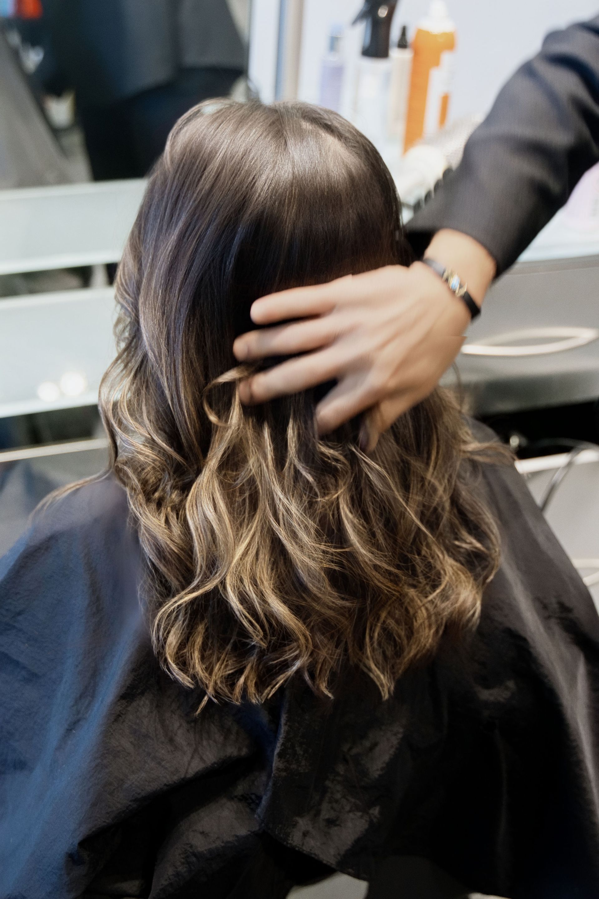 A woman is getting her hair cut at a salon