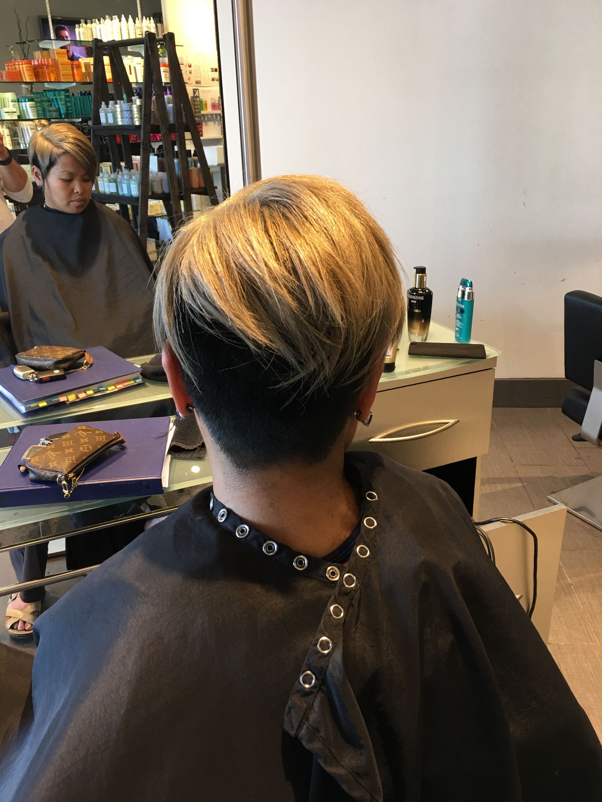 A woman is getting her hair cut in a salon