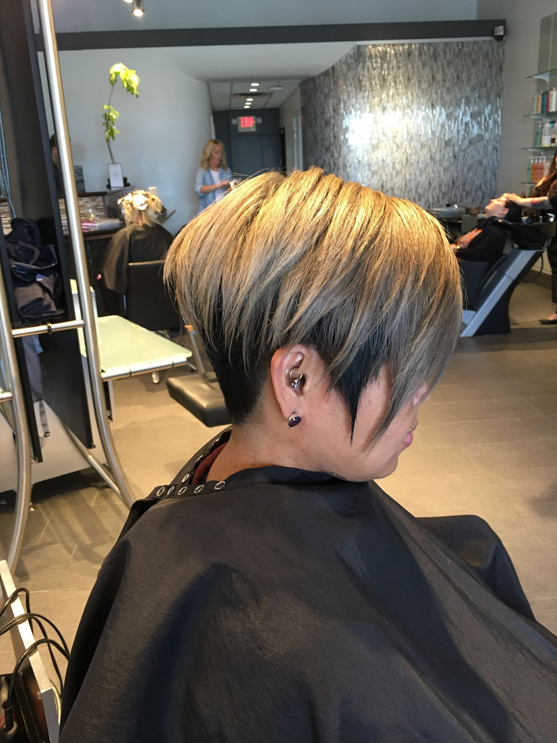 A woman is getting her hair cut in a salon.