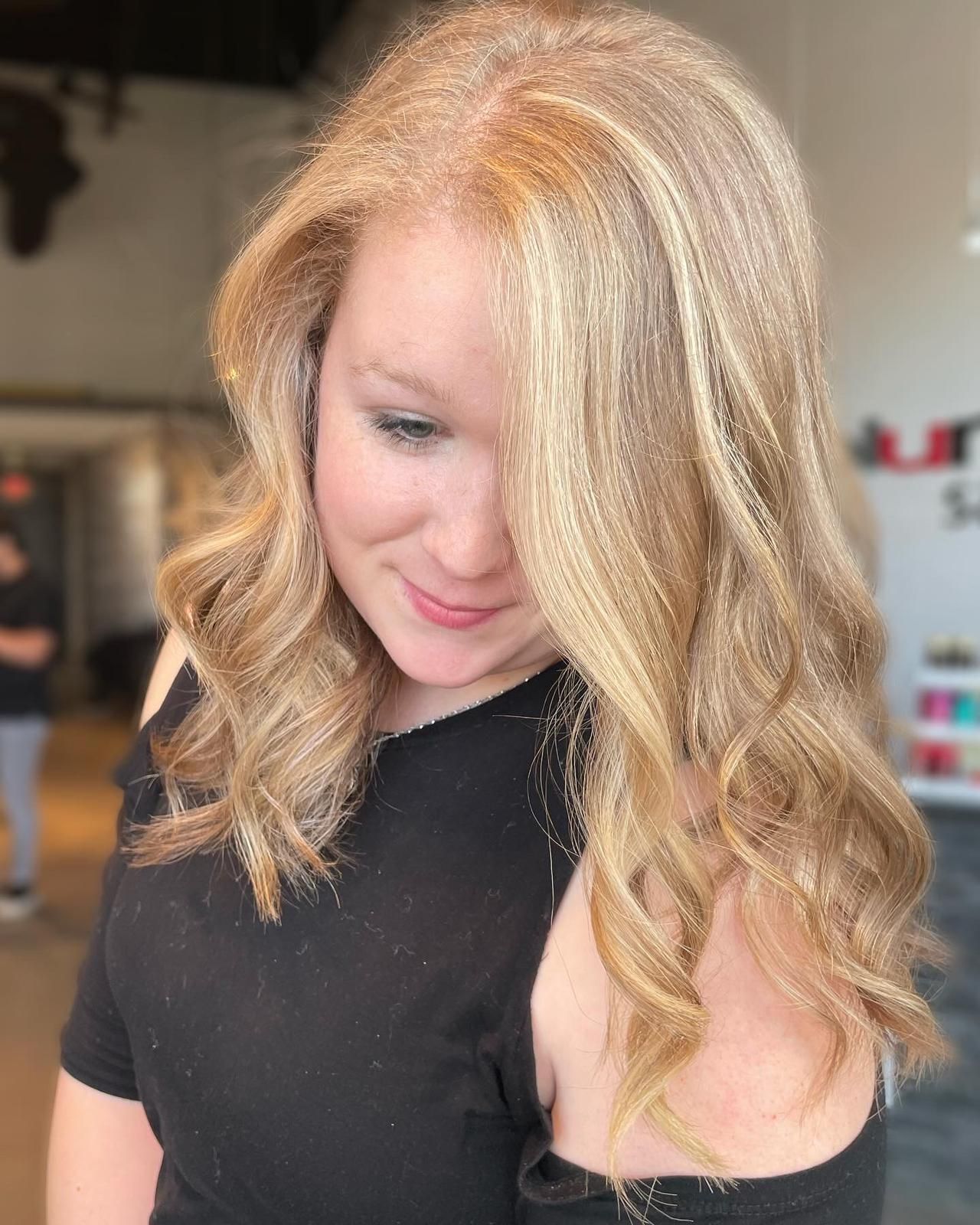 A woman with blonde hair is wearing a black shirt