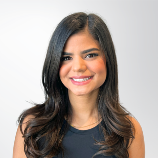 A woman with long dark hair is smiling for the camera.