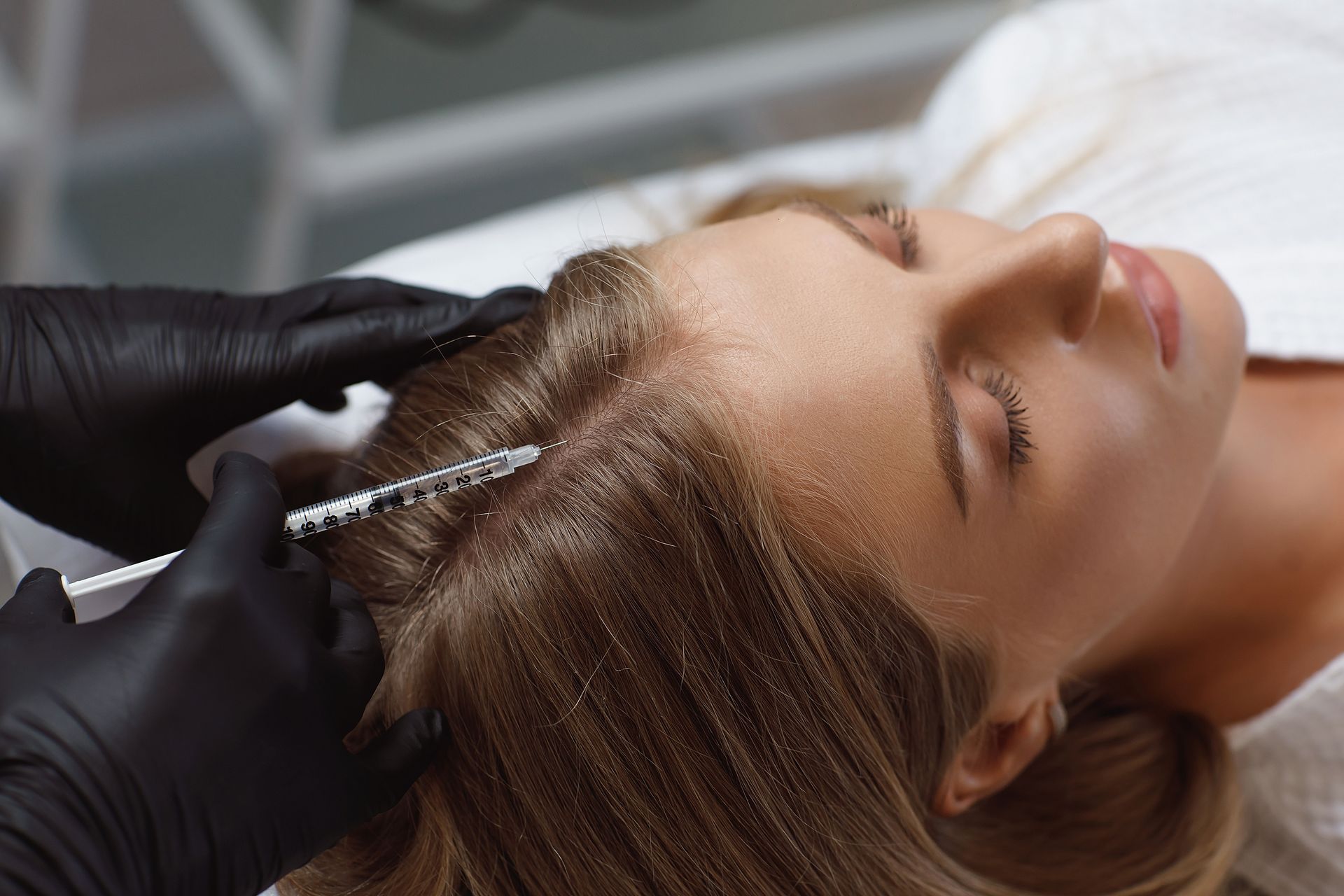 A woman is getting an injection in her hair.