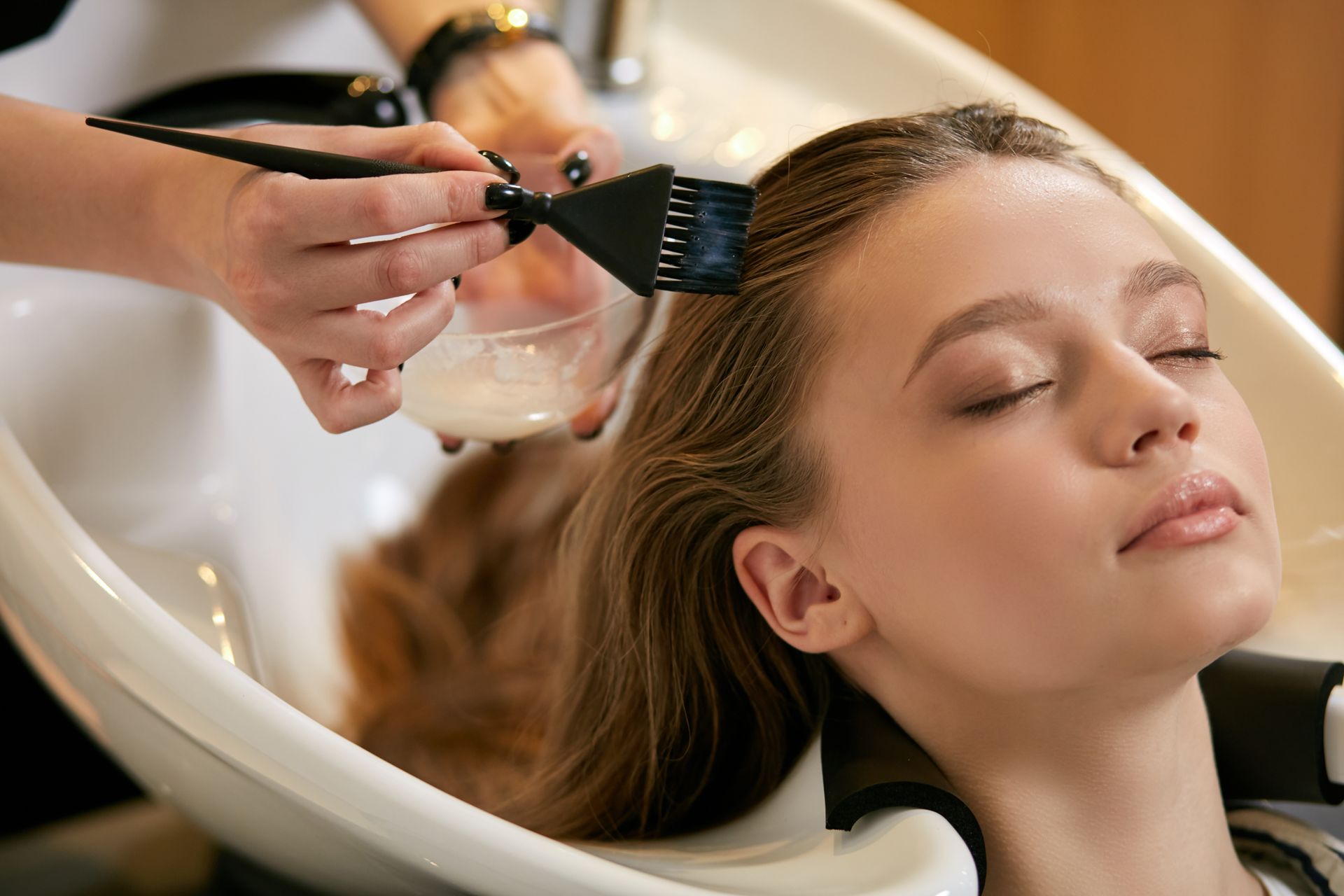 a woman is getting a hair treatment in a salon .