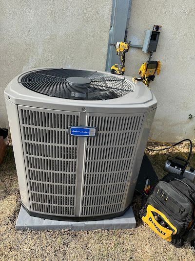 Tip of the Spear HVAC  | a large air conditioner is sitting on the ground next to a wall.