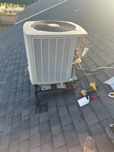 Tip of the Spear HVAC  | a large air conditioner is sitting on top of a roof.