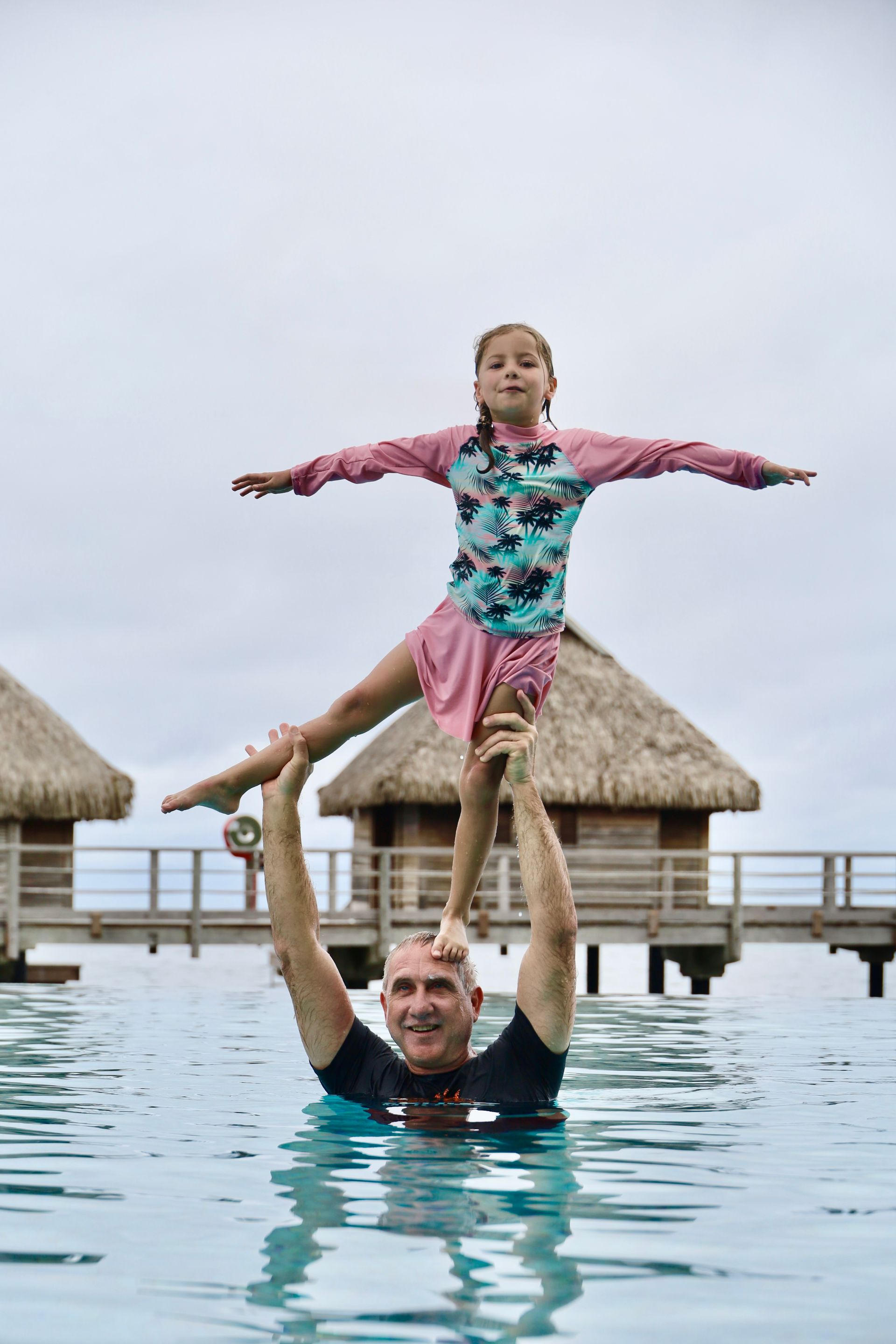 child standing on dads head