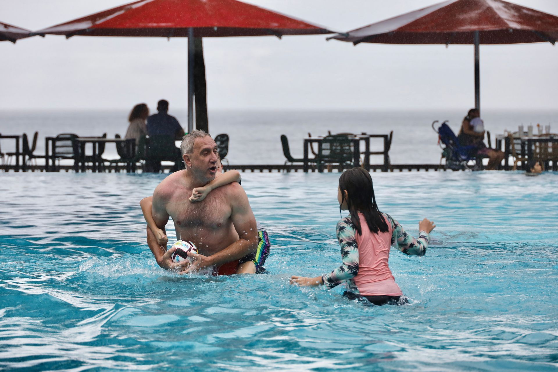 kids and dad playing in pool