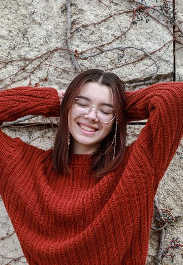 girl smiling at camera with eyes closed 