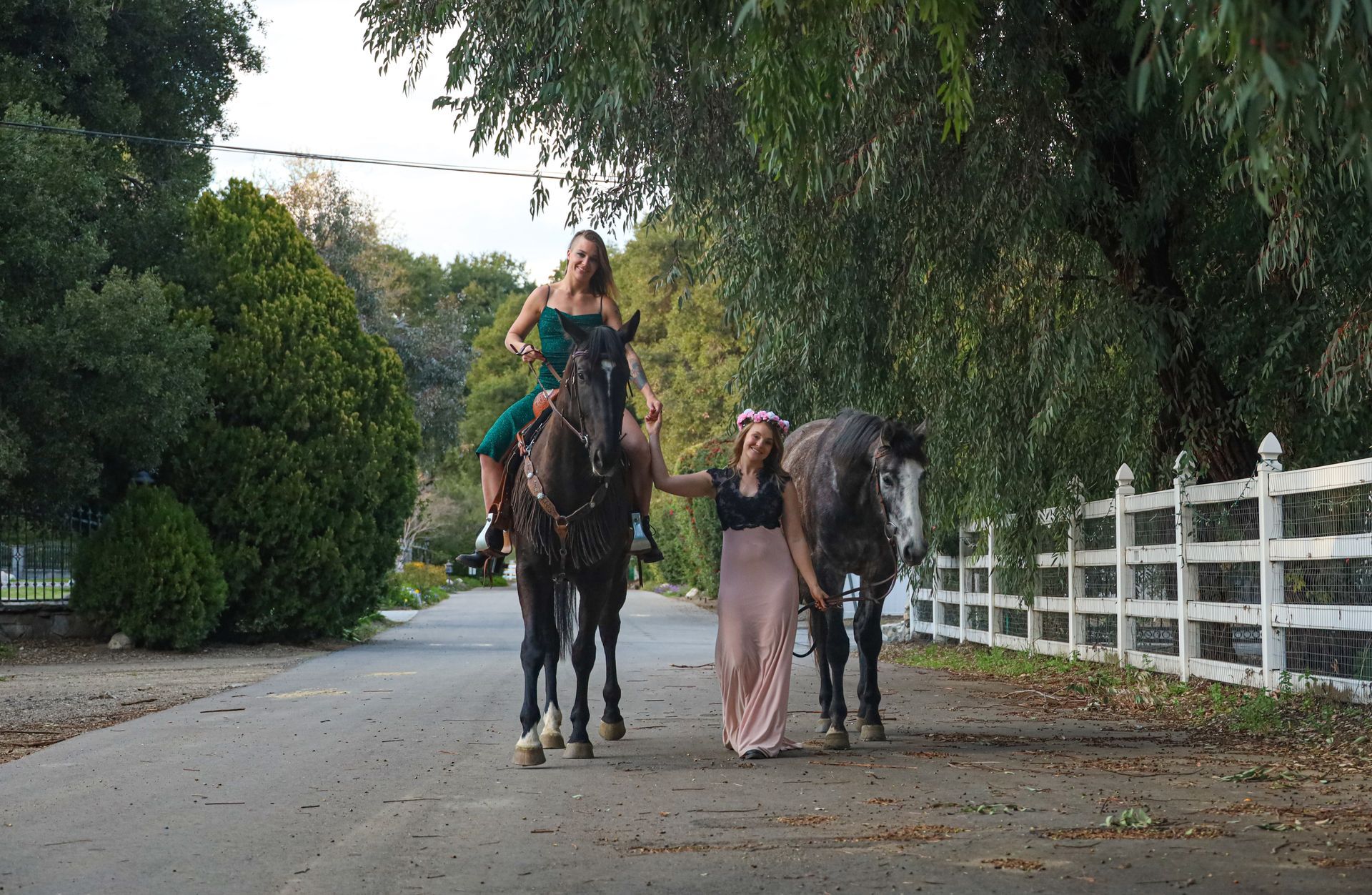 two girls and two horses walking