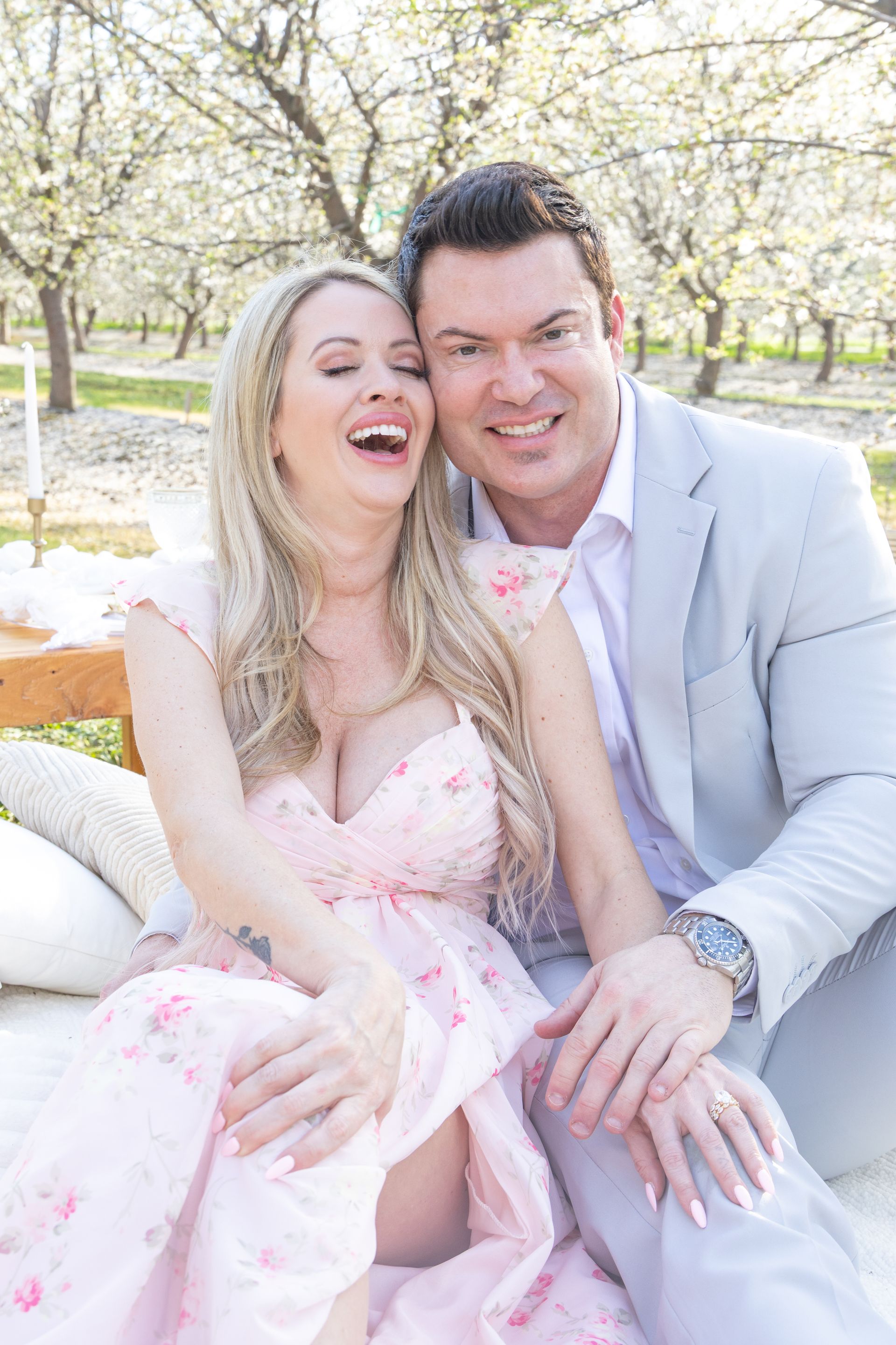 Man kissing a woman lying on a park bench, both embracing. The setting is outdoors.