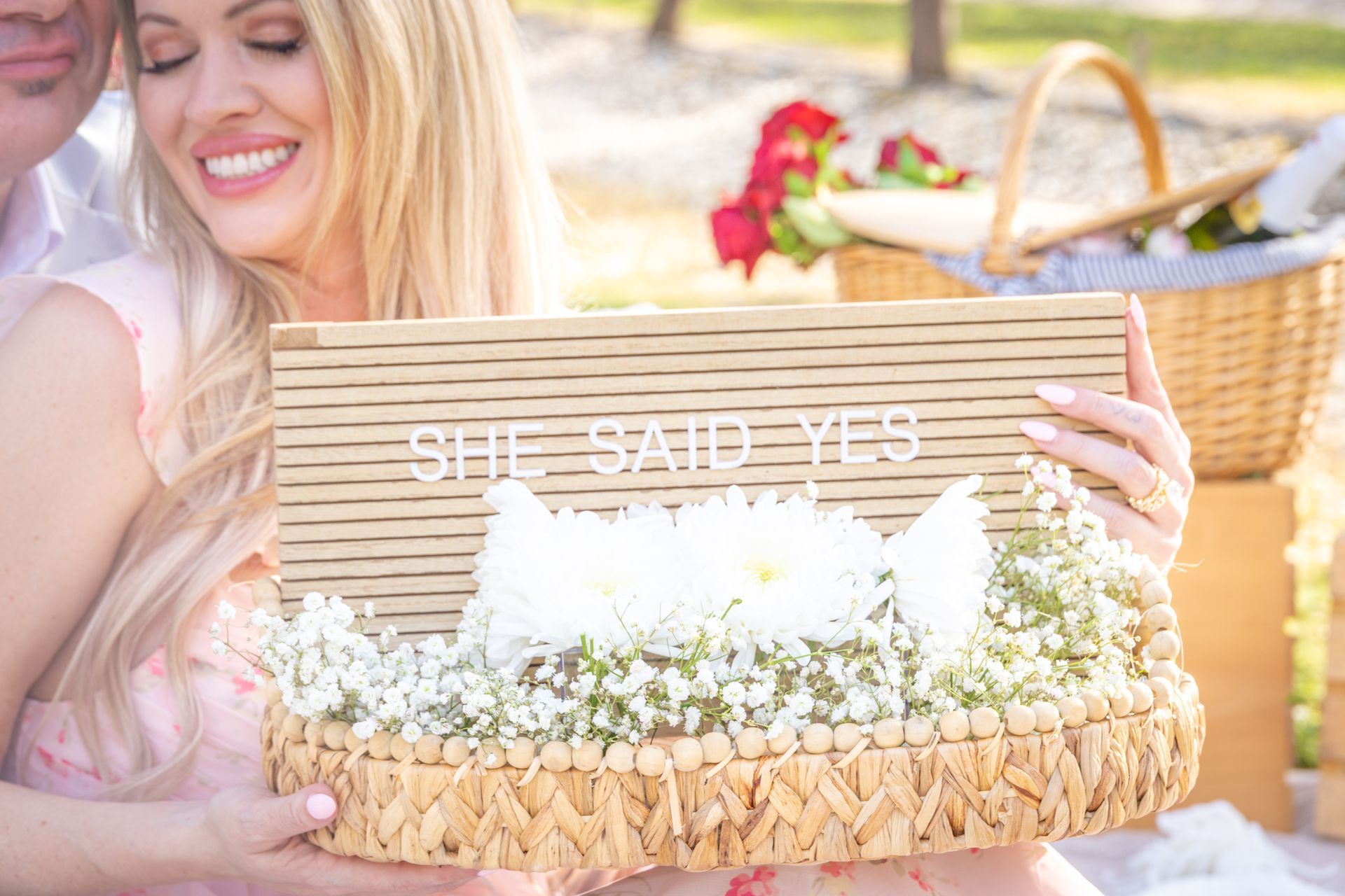 Woman kissing man on the cheek while riding piggyback outdoors. They are smiling.