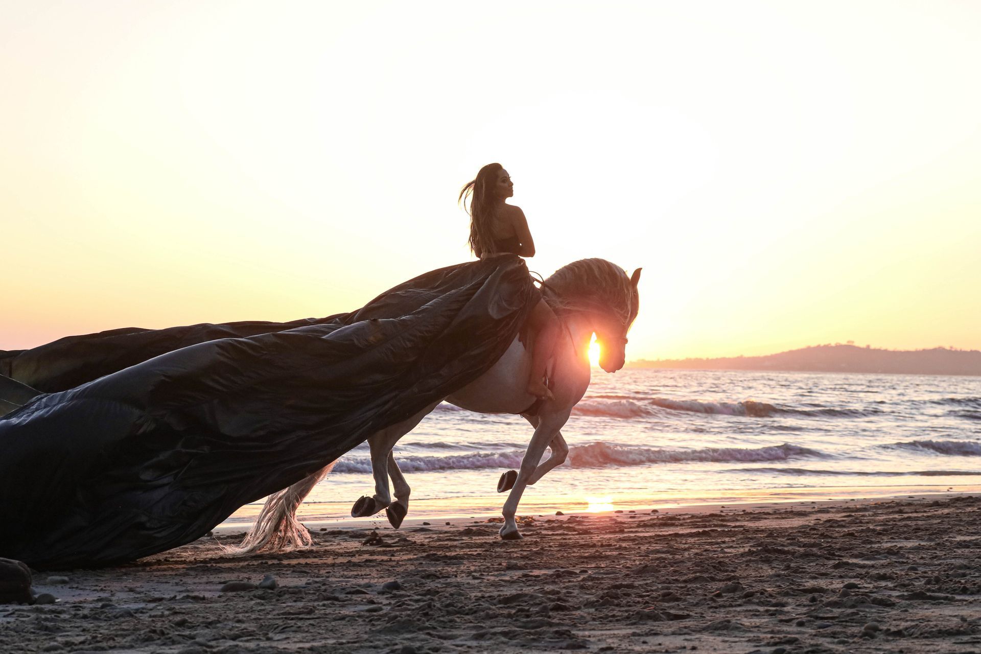 girl riding on beach at sunset