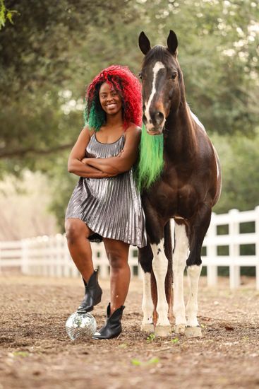 girl smiling while petting horse 