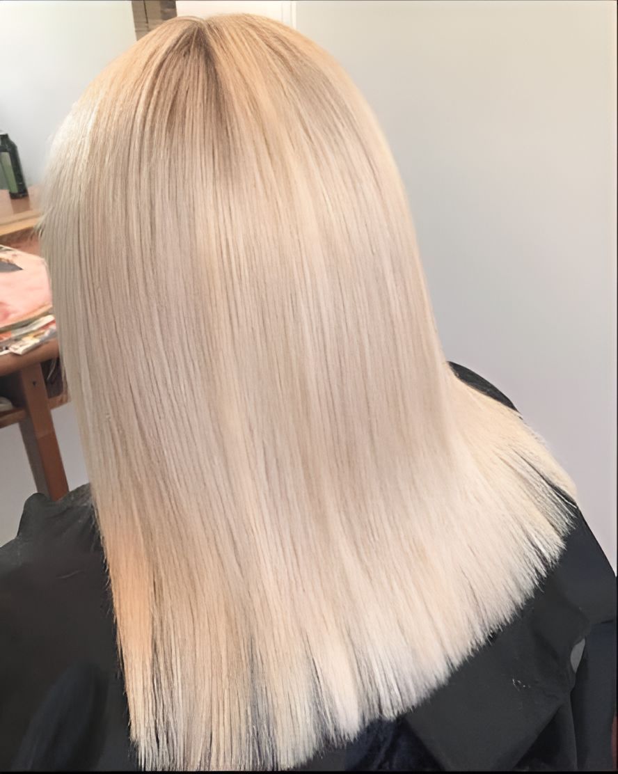 A Woman With Blonde Hair is Sitting in a Chair — Superb Hair in Wyong, NSW