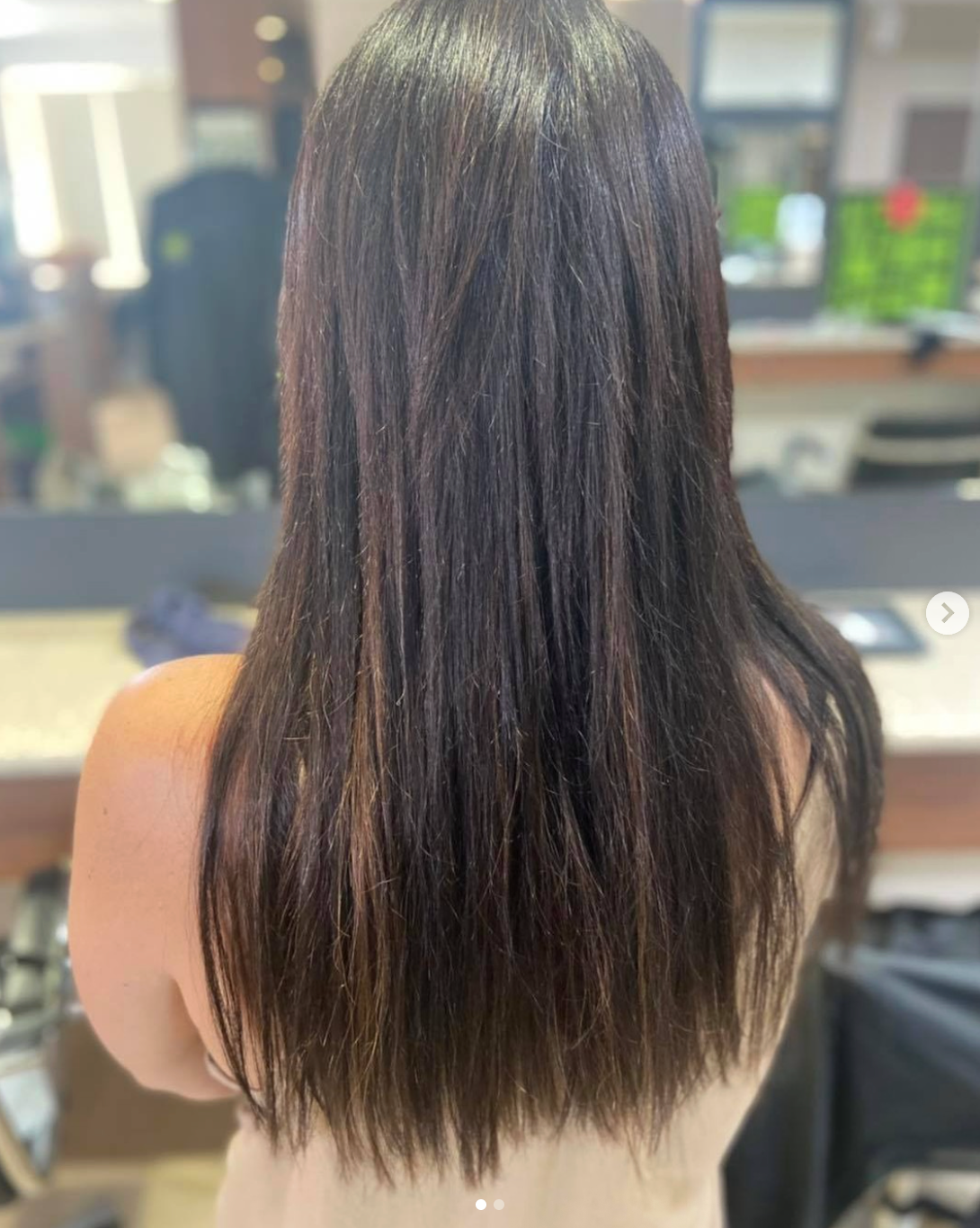 A Woman is Getting Her Hair Extensions Done by a Hairdresser — Superb Hair in Wyong, NSW