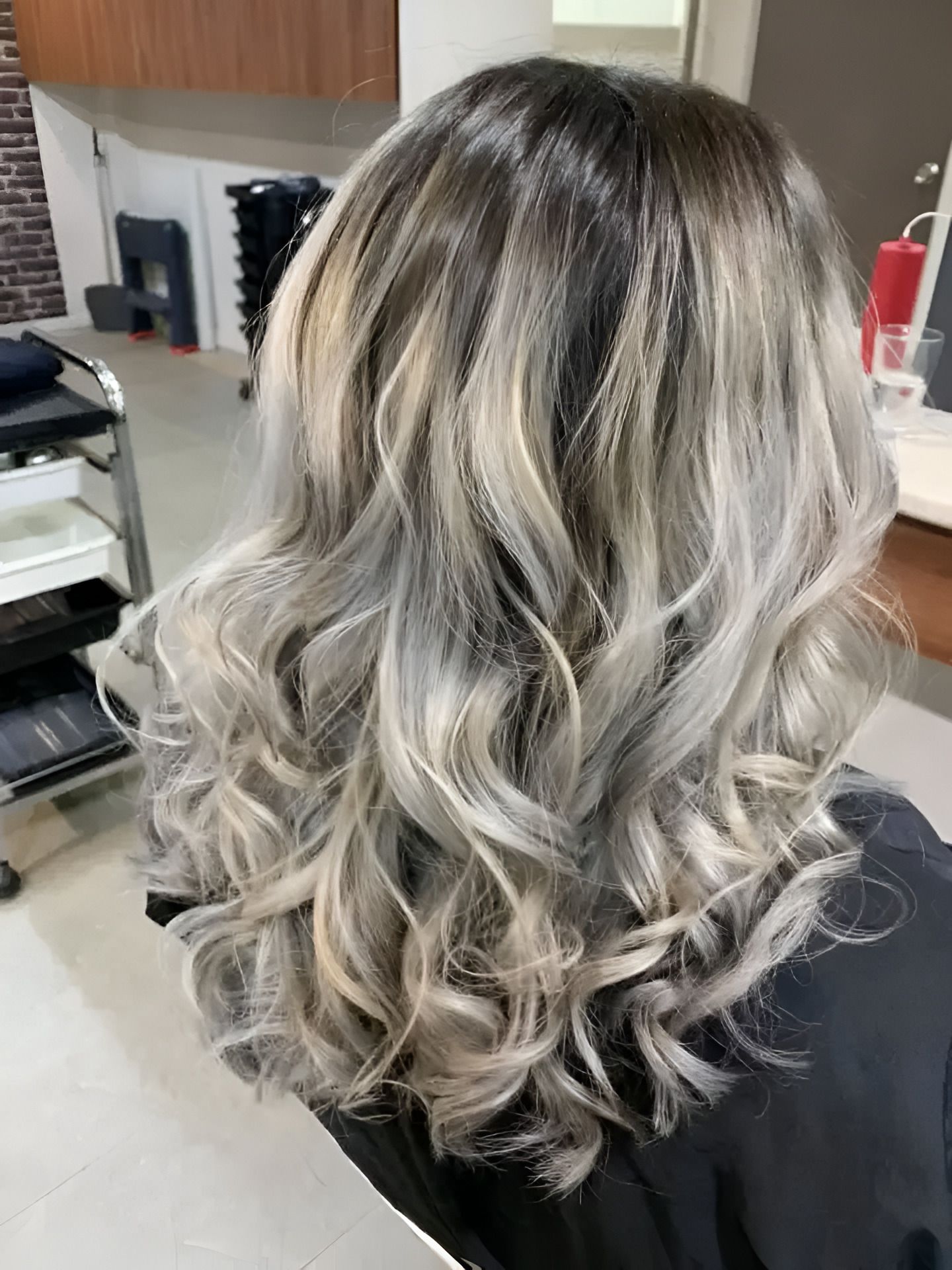 A Woman With silver Hair is Sitting in a Chair in a Salon — Superb Hair in Wyong, NSW