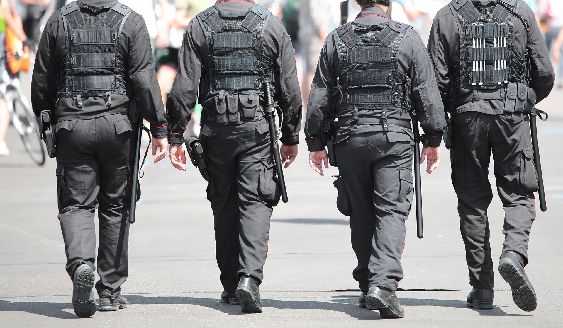 A group of security officers are walking down a street.