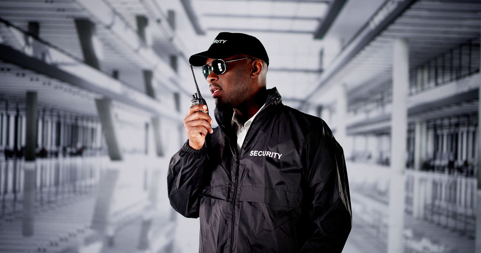 A security guard is talking on a walkie talkie in a room.