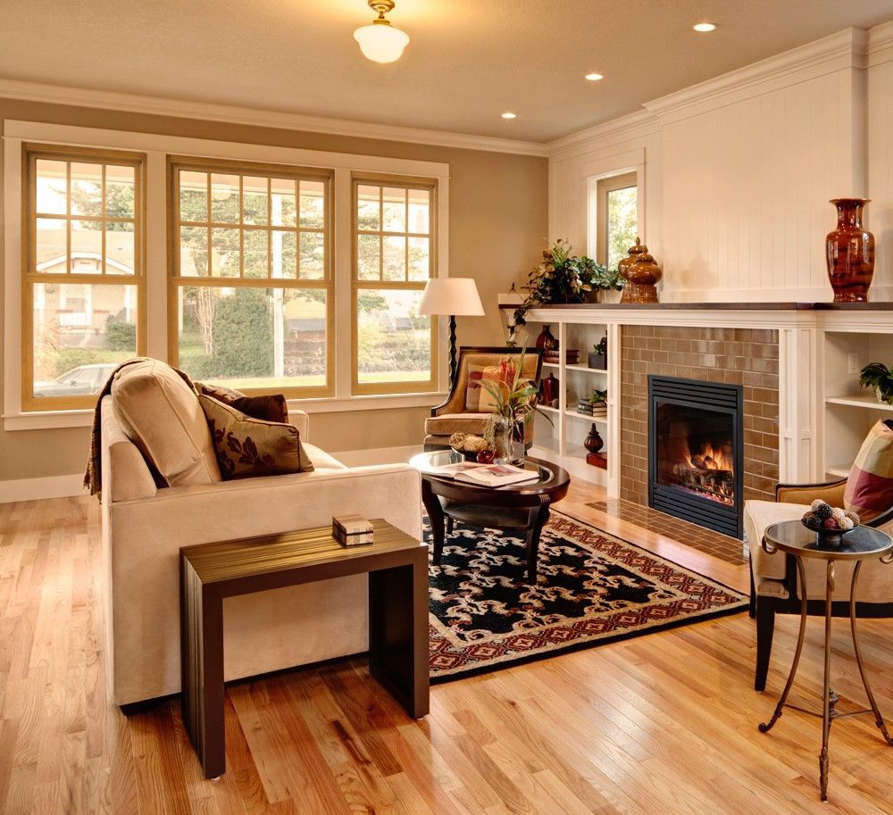 Living room with fireplace, windows, couch, coffee table, rug, and side table; natural light.