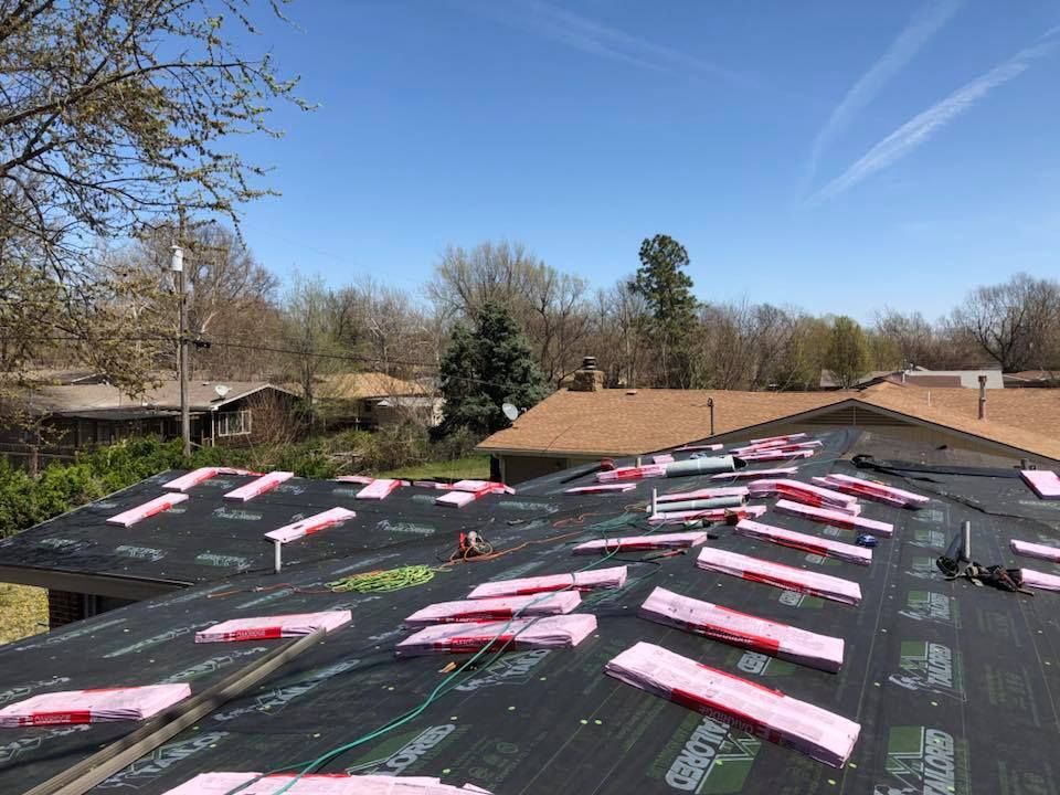 Rooftop with insulation panels laid down, ready for new roofing material. Sunny day, clear blue sky.