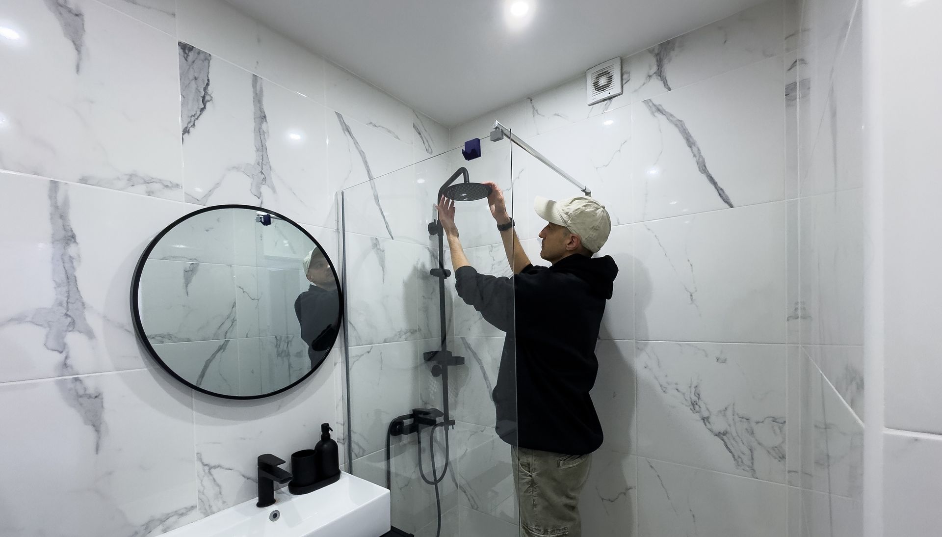 Professional installing shower enclosure during bathroom remodeling services in modern home.