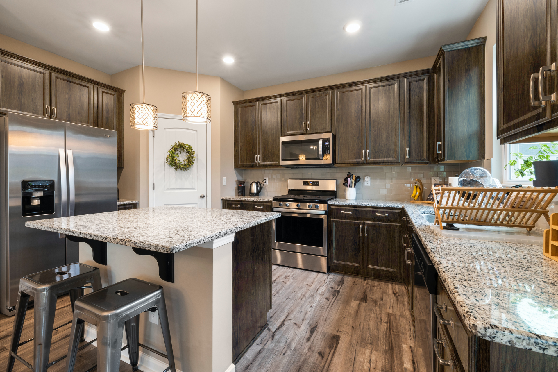 Kitchen with dark wood cabinets, stainless steel appliances, and granite countertops.