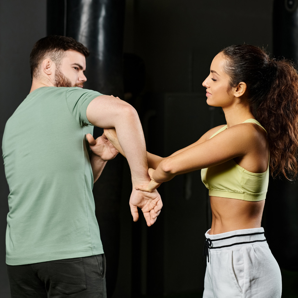 A group of children are practicing karate with a teacher in a gym.