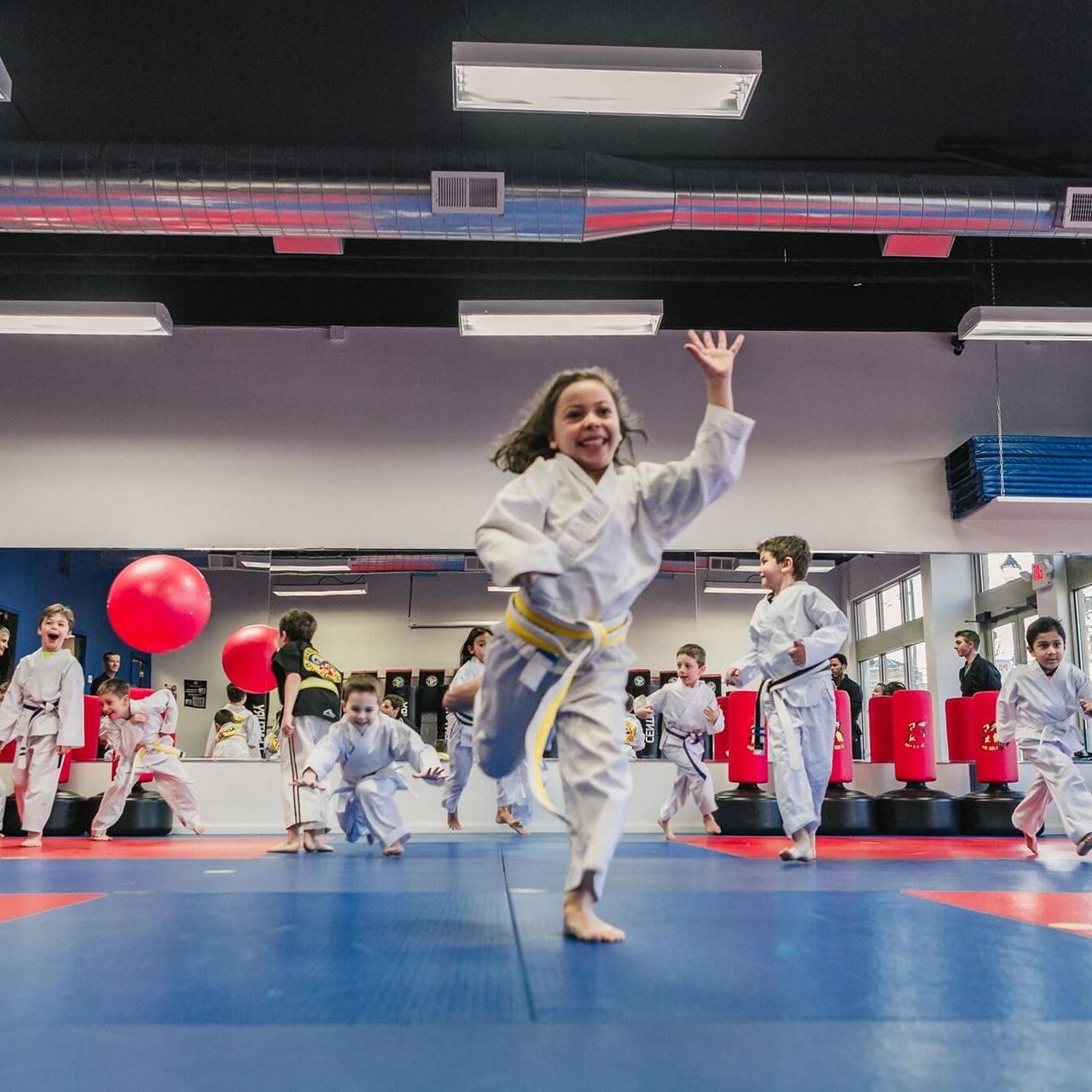 A group of children are practicing karate in a gym.