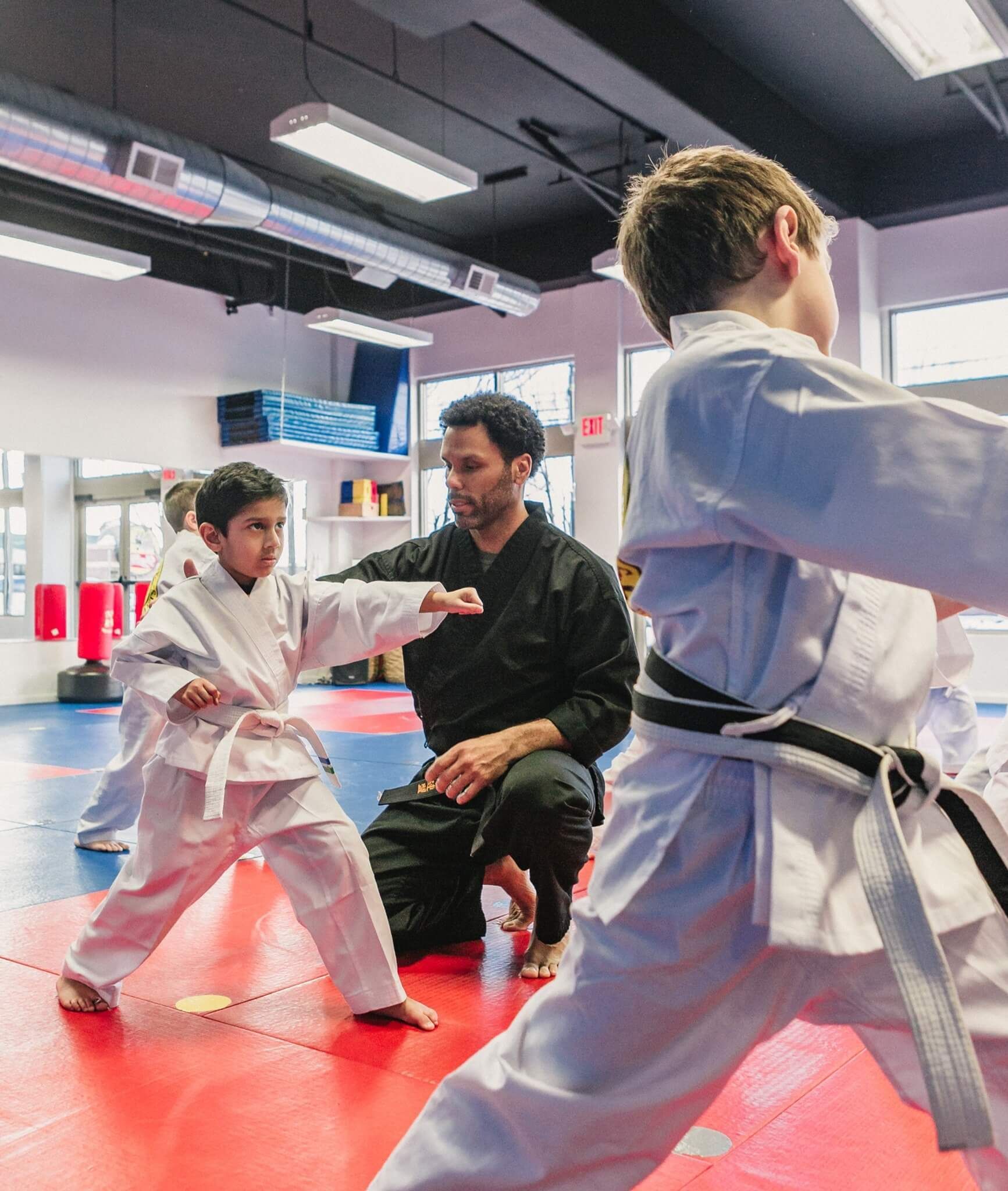 A group of young boys are practicing karate in a gym.