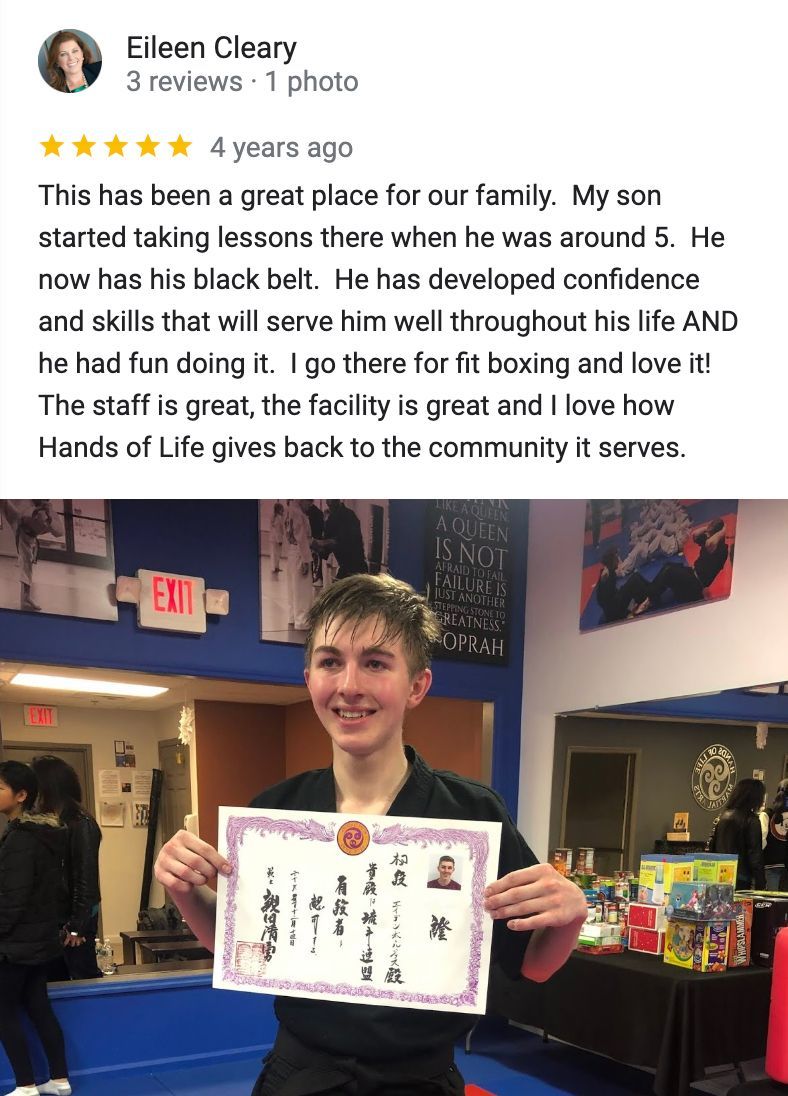 A young boy is holding a certificate in a gym.