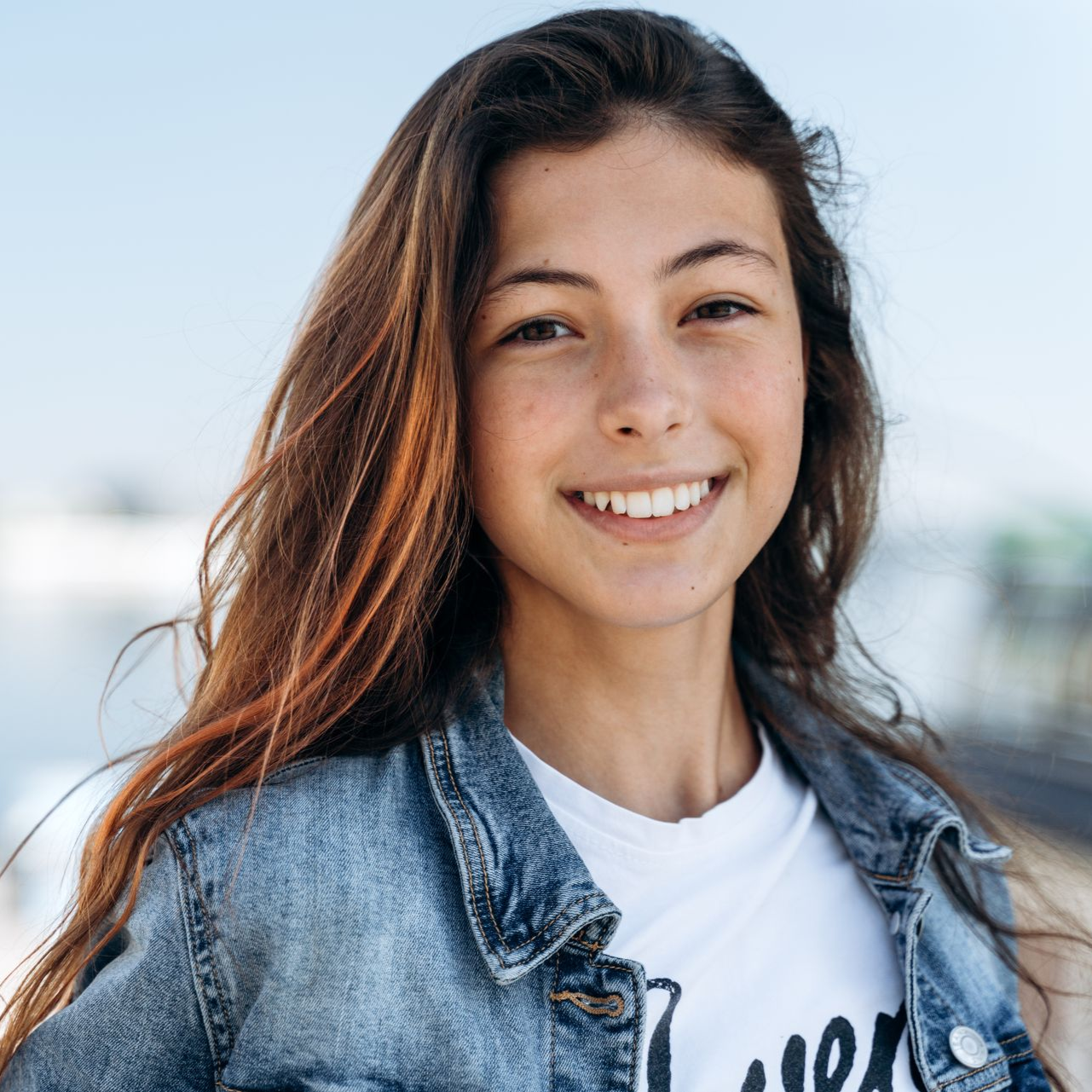 A group of kids are sitting on the floor in a martial arts class