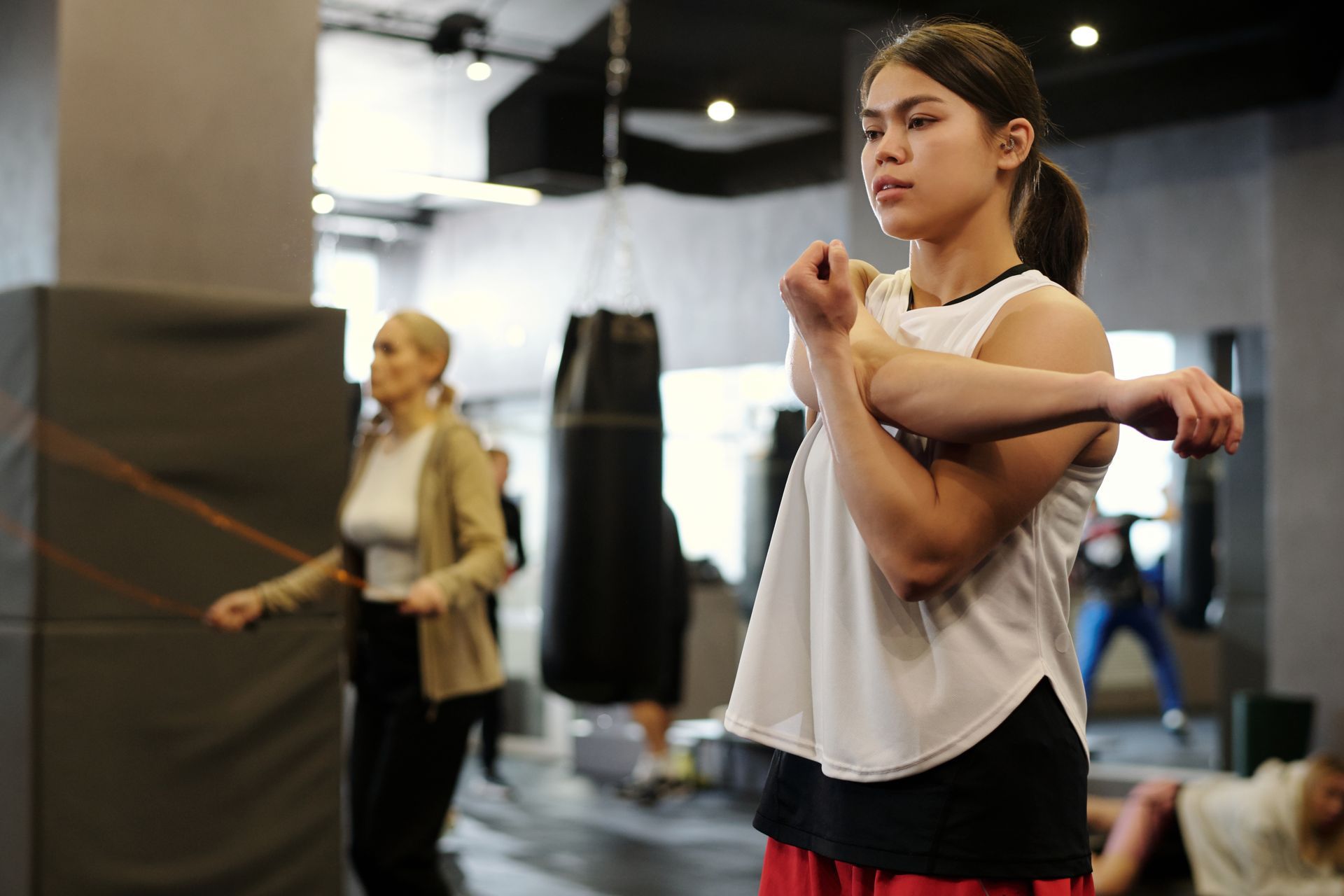A group of young karate students are posing for a picture in a gym.