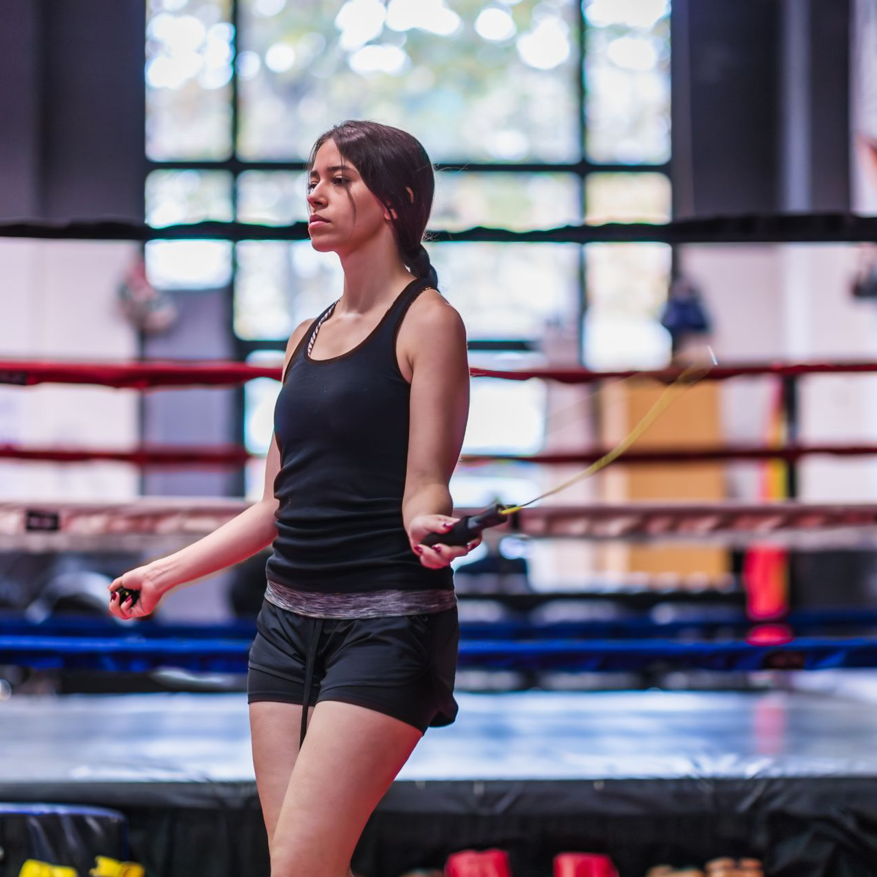 A group of kids are sitting on the floor in a martial arts class