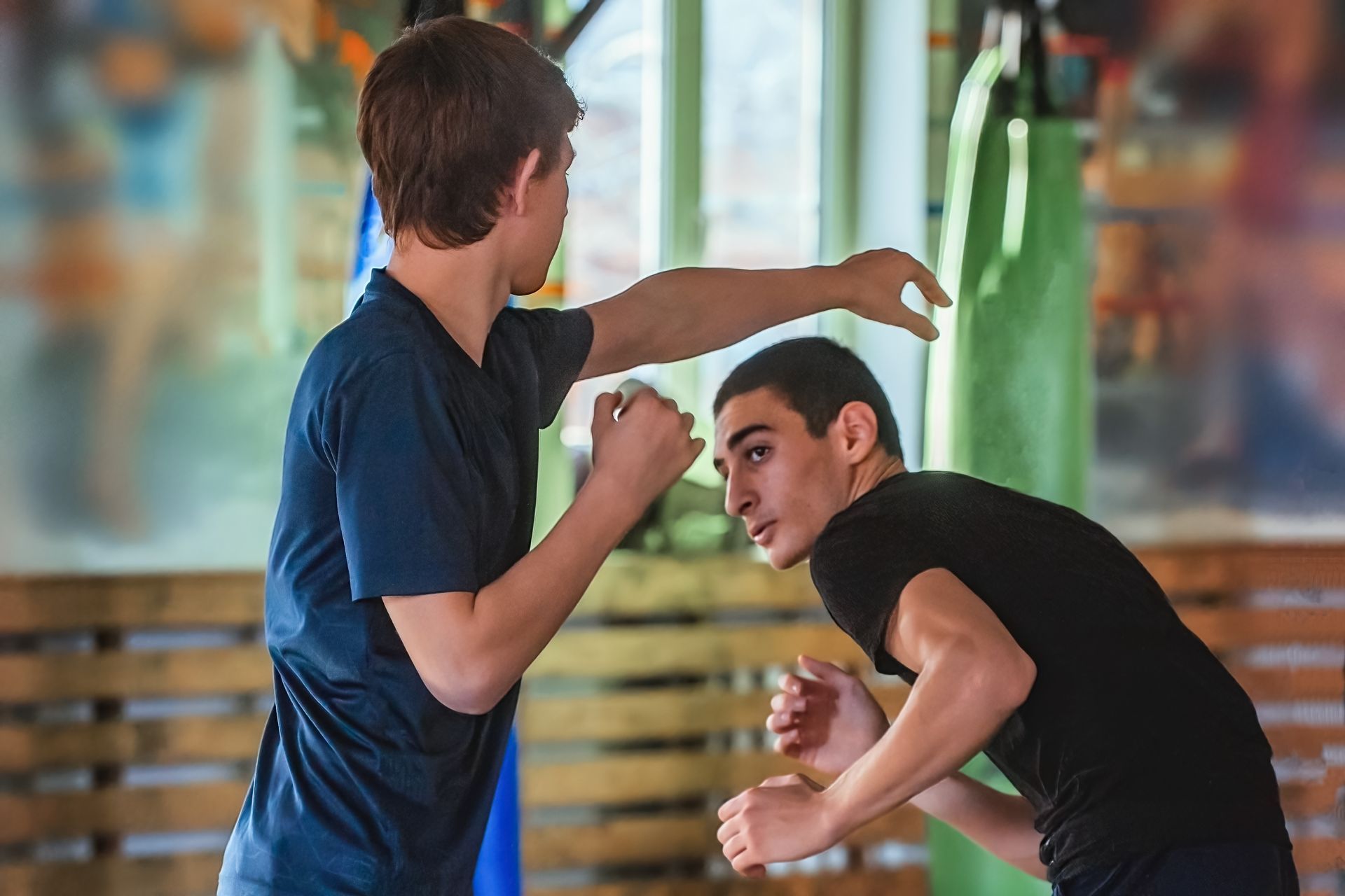 A group of people are practicing martial arts in a gym.