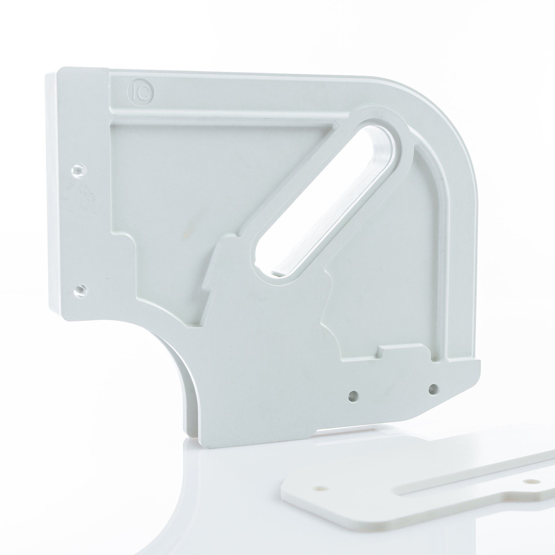 Un objet en plastique blanc est posé sur une surface blanche.