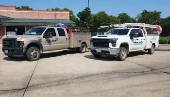 Two work trucks parked outside a building.