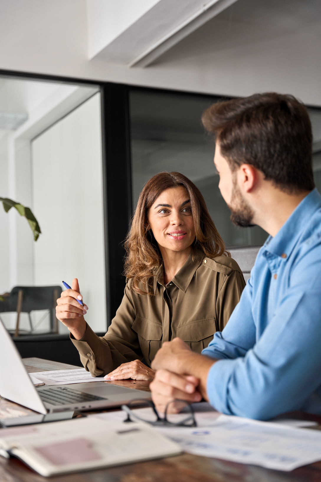 A man is sitting at a desk using a laptop and a tablet.