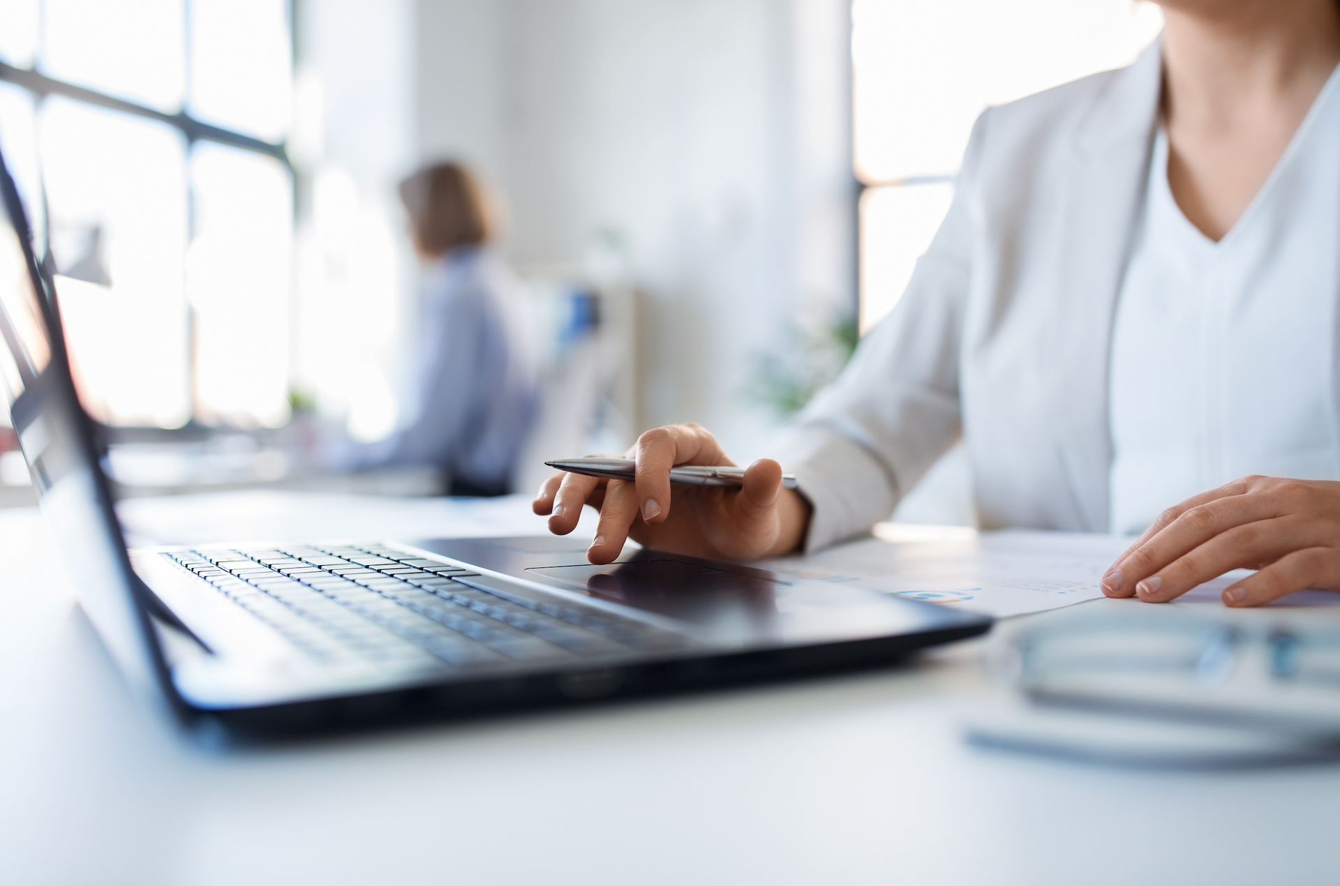 A man is sitting at a desk using a laptop and a tablet.
