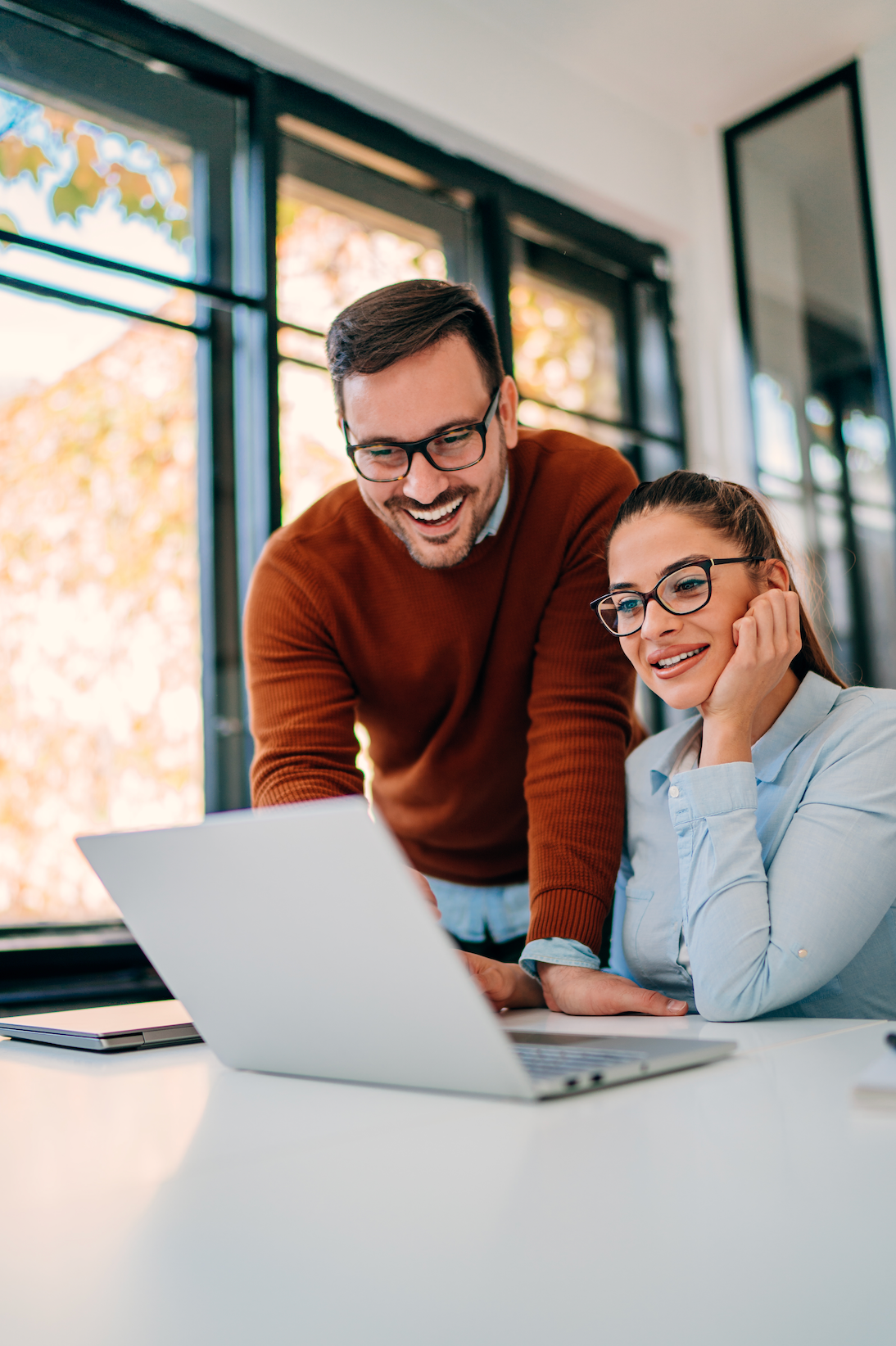 A man is sitting at a desk using a laptop and a tablet.