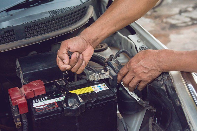 Car Mechanic Installing Car  Battery — Tyres, Turbos & 4WD's In Cardiff NSW