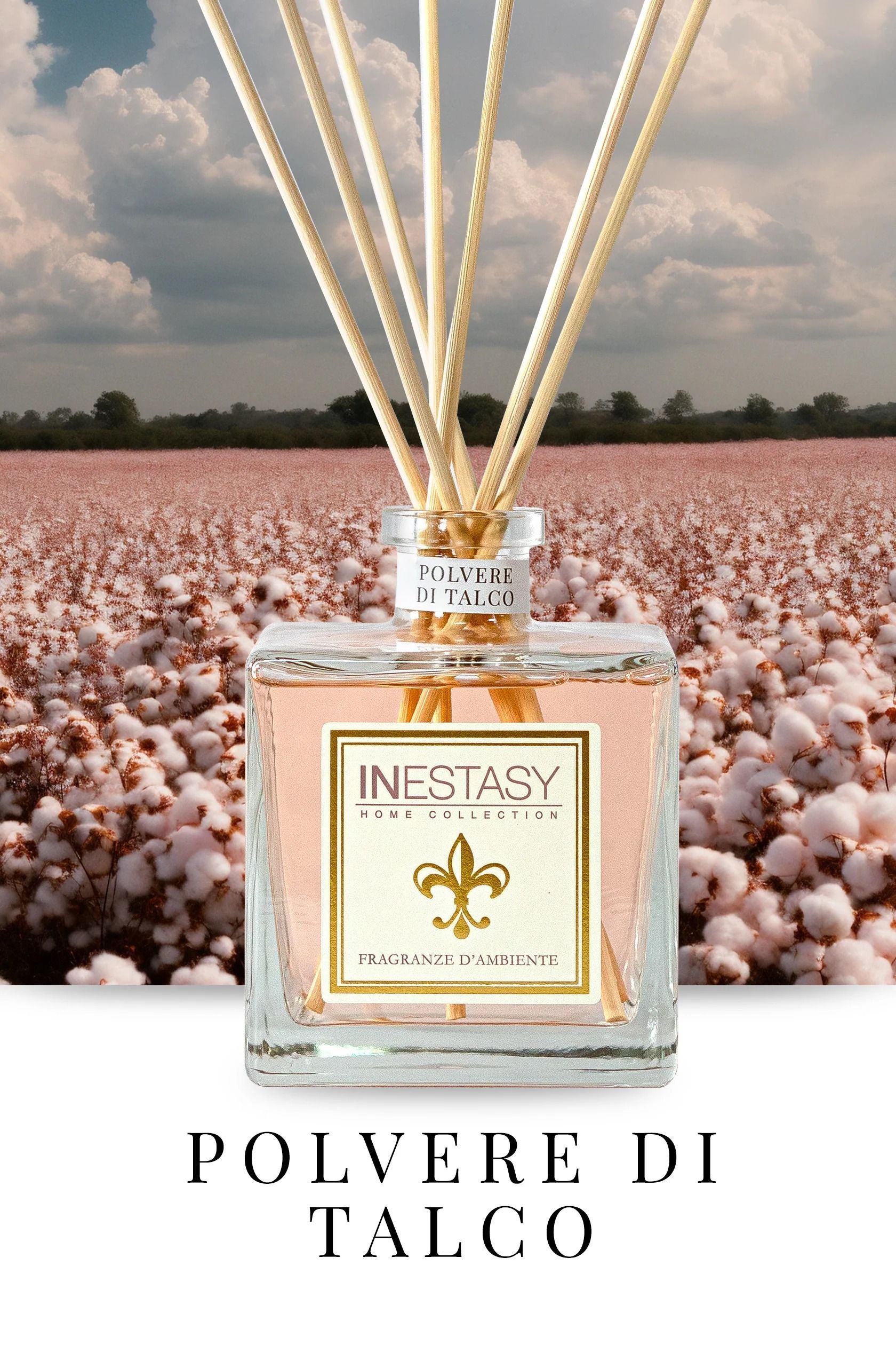 Una bottiglia di profumo con dei bastoncini davanti a un campo di cotone.
